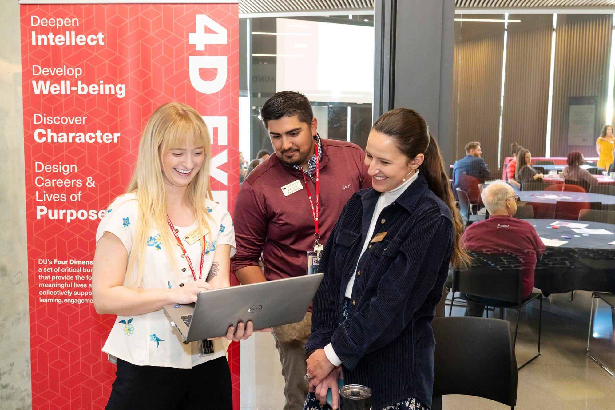 People gathered around a laptop