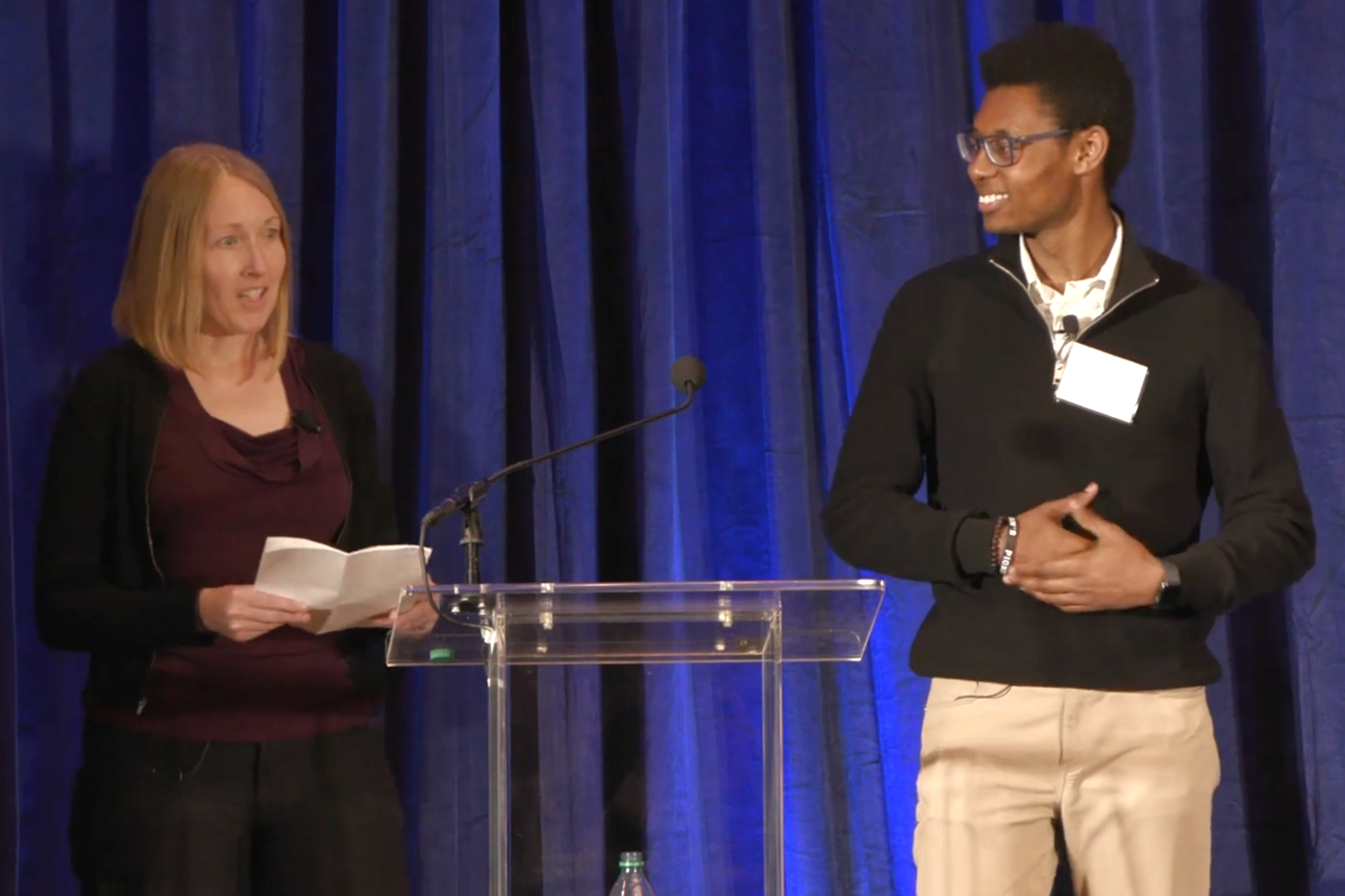 A man and a woman talking on stage